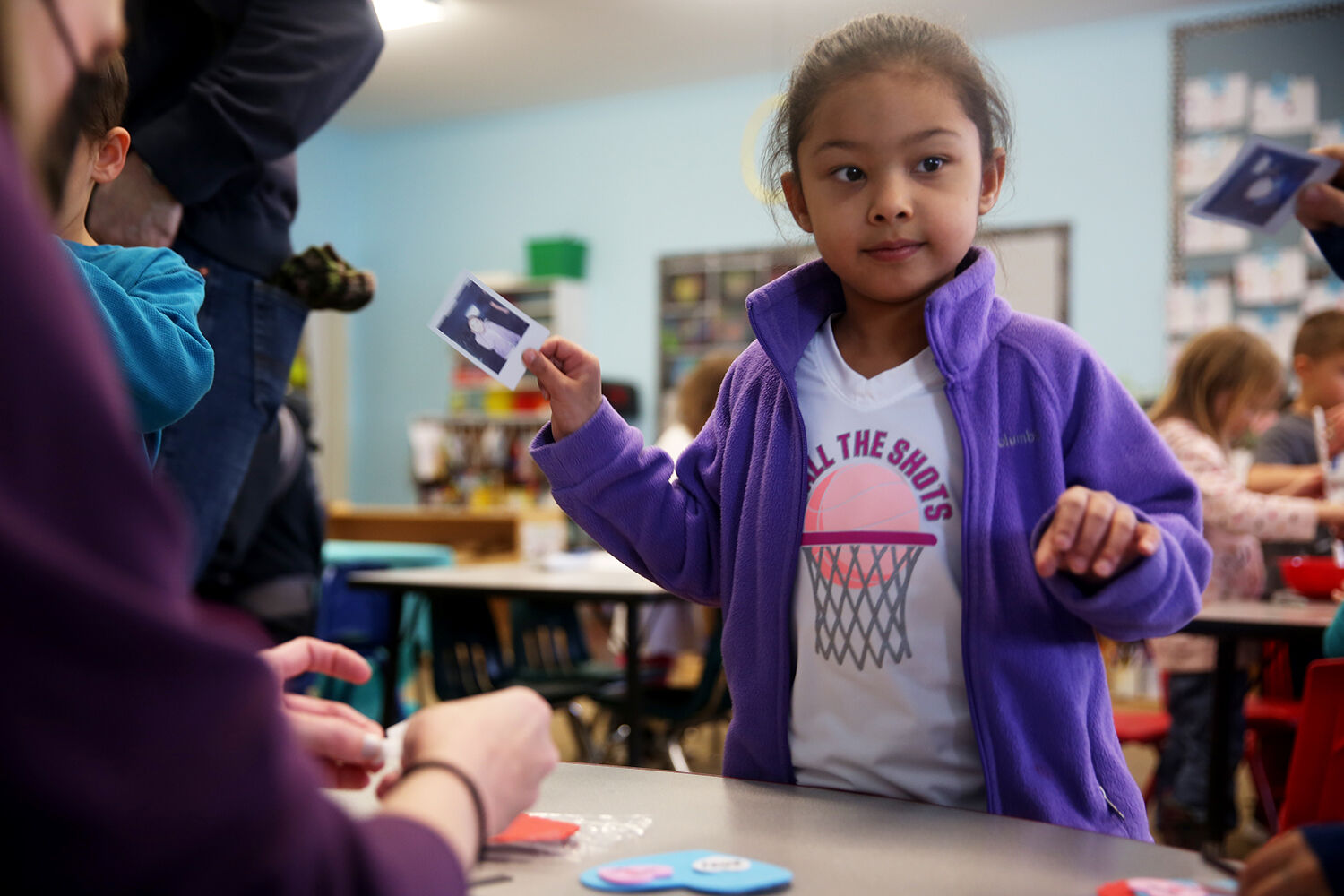 Kindergartener Kinzley Patterson waves her polaroid photo